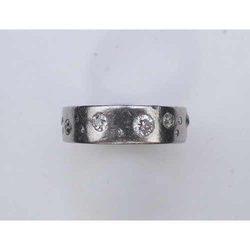 423 - A platinum and diamond eternity ring, set with a continuous band of scattered brilliant-cut diamonds... 