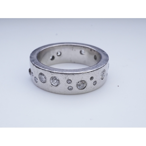 423 - A platinum and diamond eternity ring, set with a continuous band of scattered brilliant-cut diamonds... 