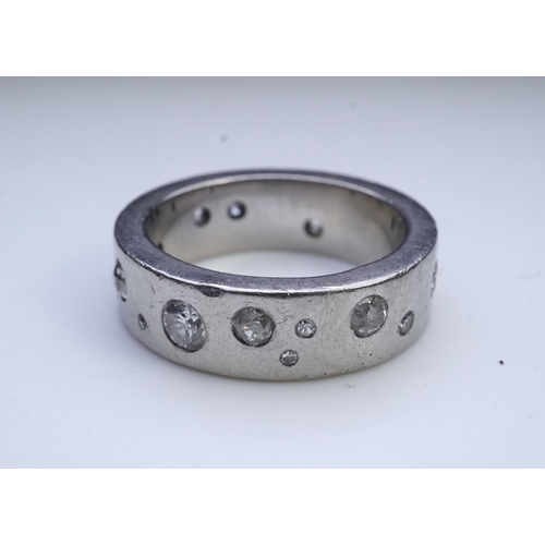 423 - A platinum and diamond eternity ring, set with a continuous band of scattered brilliant-cut diamonds... 