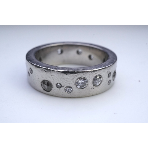 423 - A platinum and diamond eternity ring, set with a continuous band of scattered brilliant-cut diamonds... 