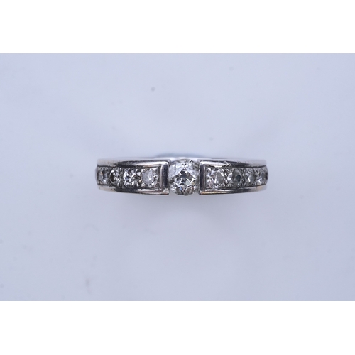 426 - A diamond eternity ring, centring on a tension-set circular-cut diamond weighing approximately 0.25 ... 