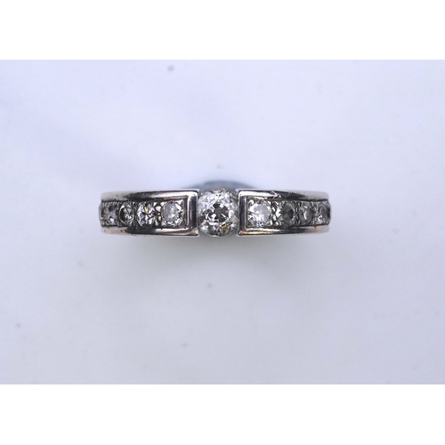 426 - A diamond eternity ring, centring on a tension-set circular-cut diamond weighing approximately 0.25 ... 