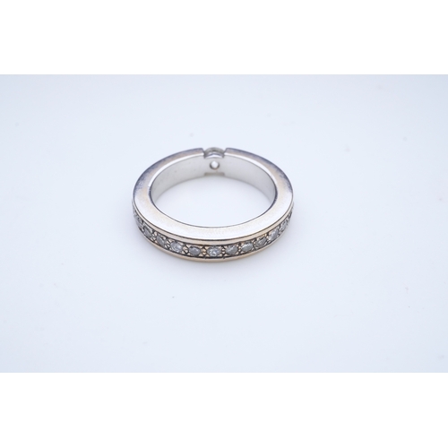 426 - A diamond eternity ring, centring on a tension-set circular-cut diamond weighing approximately 0.25 ... 