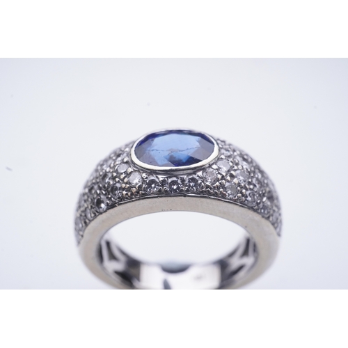 432 - A sapphire and diamond ring, of bombé design, collet-set with an oval sapphire, to shoulders pavé-se... 