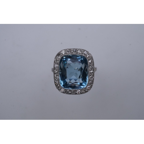 436 - An attractive aquamarine and diamond ring, of cluster design, set with a cushion-shaped aquamarine, ... 