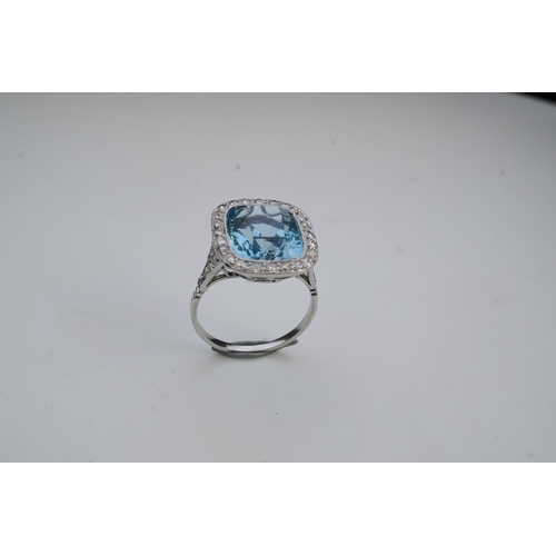 436 - An attractive aquamarine and diamond ring, of cluster design, set with a cushion-shaped aquamarine, ... 