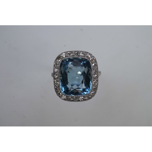 436 - An attractive aquamarine and diamond ring, of cluster design, set with a cushion-shaped aquamarine, ... 