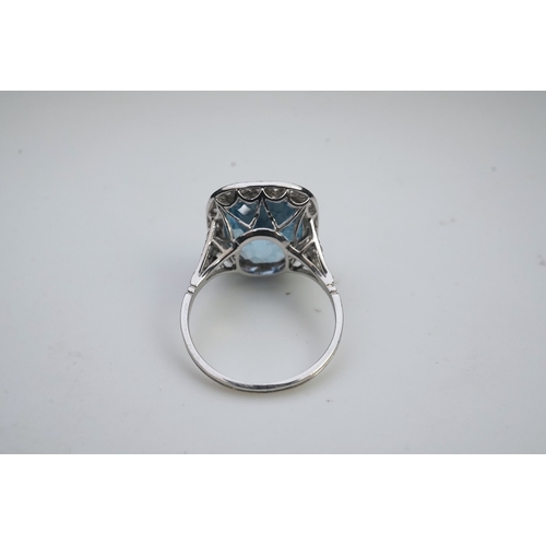 436 - An attractive aquamarine and diamond ring, of cluster design, set with a cushion-shaped aquamarine, ... 