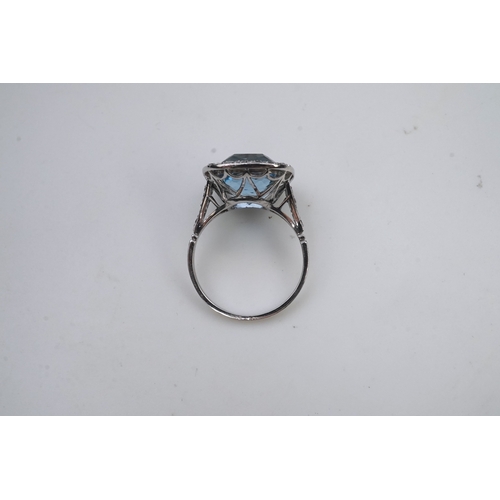 436 - An attractive aquamarine and diamond ring, of cluster design, set with a cushion-shaped aquamarine, ... 