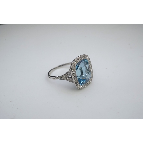 436 - An attractive aquamarine and diamond ring, of cluster design, set with a cushion-shaped aquamarine, ... 