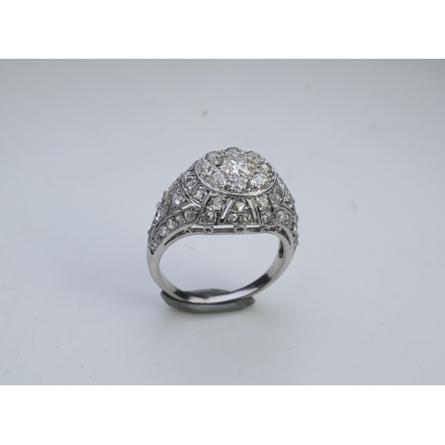 437 - A diamond dress ring, in the Belle Epoque style, of bombé design in millegrain-bordered openwork, se... 