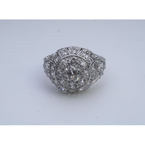 437 - A diamond dress ring, in the Belle Epoque style, of bombé design in millegrain-bordered openwork, se... 