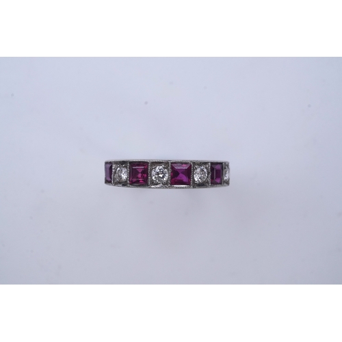 439 - A ruby and diamond half eternity ring, set to the front with a band of step-cut rubies and brilliant... 