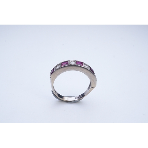 439 - A ruby and diamond half eternity ring, set to the front with a band of step-cut rubies and brilliant... 