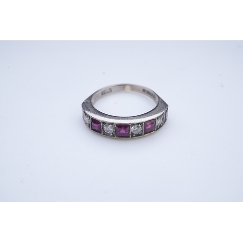 439 - A ruby and diamond half eternity ring, set to the front with a band of step-cut rubies and brilliant... 