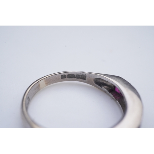 439 - A ruby and diamond half eternity ring, set to the front with a band of step-cut rubies and brilliant... 