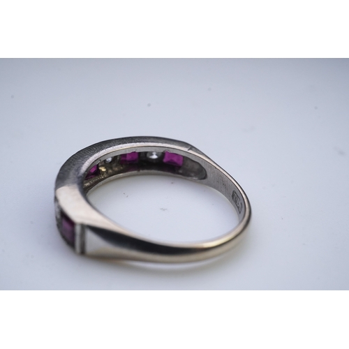 439 - A ruby and diamond half eternity ring, set to the front with a band of step-cut rubies and brilliant... 