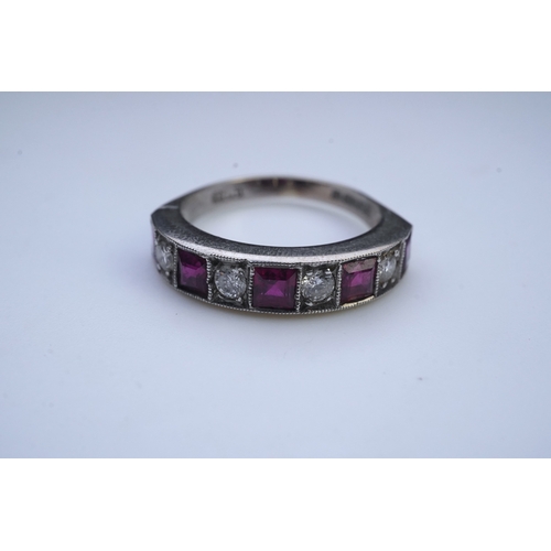 439 - A ruby and diamond half eternity ring, set to the front with a band of step-cut rubies and brilliant... 