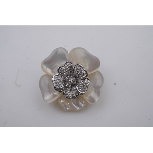 441 - A mother of pearl and diamond pendant designed as a flower in carved mother of pearl, the centre pav... 