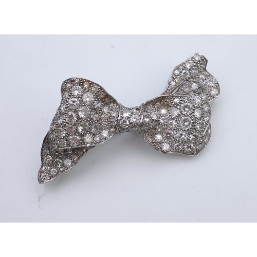 442 - A diamond brooch, mid 20th century, designed as a ribbon bow, pavé-set with circular- and single-cut... 