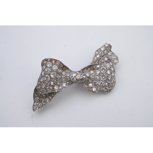 442 - A diamond brooch, mid 20th century, designed as a ribbon bow, pavé-set with circular- and single-cut... 