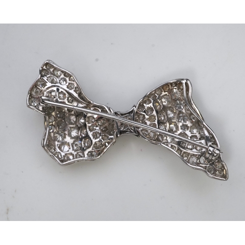 442 - A diamond brooch, mid 20th century, designed as a ribbon bow, pavé-set with circular- and single-cut... 