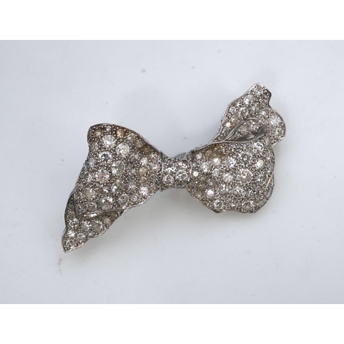 442 - A diamond brooch, mid 20th century, designed as a ribbon bow, pavé-set with circular- and single-cut... 