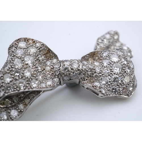 442 - A diamond brooch, mid 20th century, designed as a ribbon bow, pavé-set with circular- and single-cut... 