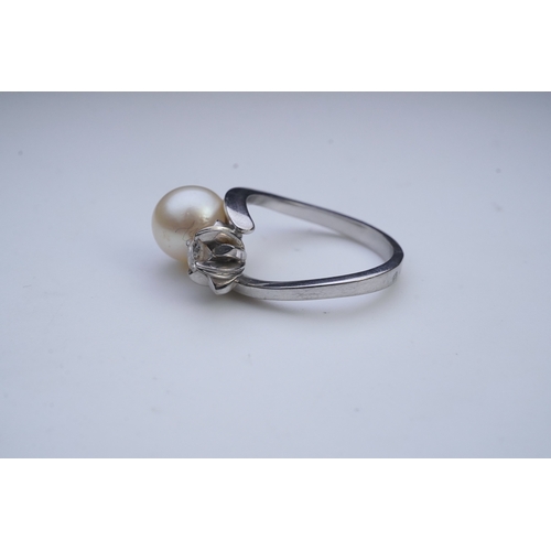 443 - A cultured pearl and diamond toi-et-moi ring, of crossover design, set with a cultured pearl and a c... 