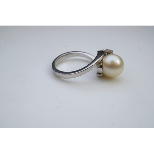 443 - A cultured pearl and diamond toi-et-moi ring, of crossover design, set with a cultured pearl and a c... 