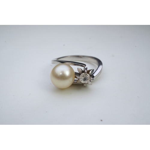 443 - A cultured pearl and diamond toi-et-moi ring, of crossover design, set with a cultured pearl and a c... 