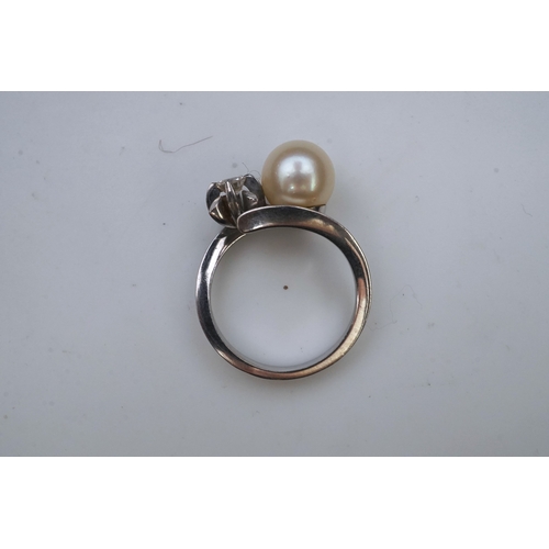 443 - A cultured pearl and diamond toi-et-moi ring, of crossover design, set with a cultured pearl and a c... 