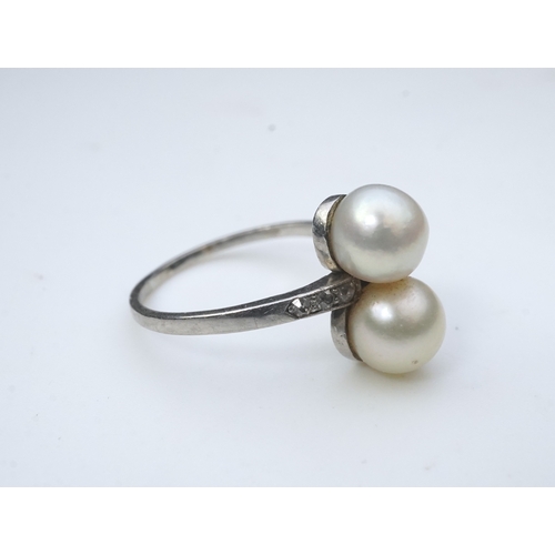 444 - A pearl and diamond toi-et-moi ring, circa 1920 set with a pair of pearls, each measuring approximat... 