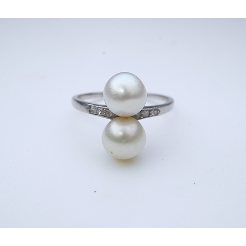 444 - A pearl and diamond toi-et-moi ring, circa 1920 set with a pair of pearls, each measuring approximat... 