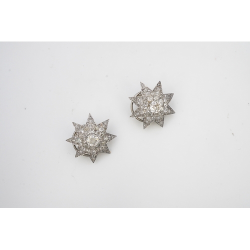 449 - A pair of Art Deco diamond ear clips, 1930s, each designed as an eight-rayed star, pavé-set with cus... 