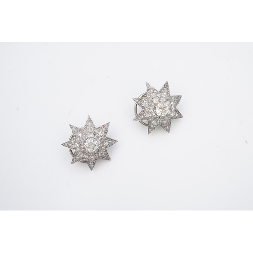 449 - A pair of Art Deco diamond ear clips, 1930s, each designed as an eight-rayed star, pavé-set with cus... 