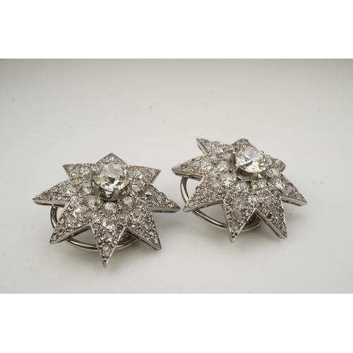 449 - A pair of Art Deco diamond ear clips, 1930s, each designed as an eight-rayed star, pavé-set with cus... 