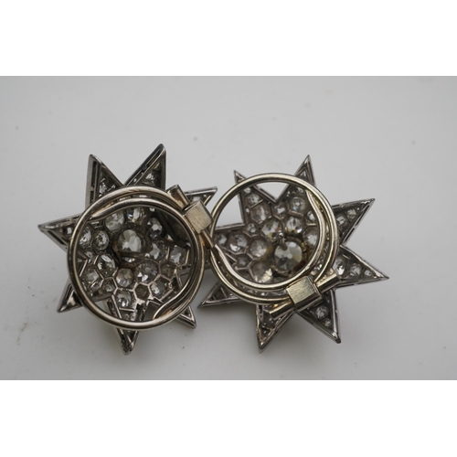 449 - A pair of Art Deco diamond ear clips, 1930s, each designed as an eight-rayed star, pavé-set with cus... 