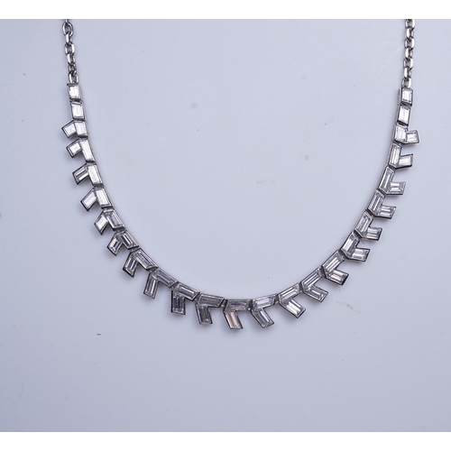 455 - A diamond necklace, the front composed of geometric links set with rhomboid baguette diamonds, to a ... 