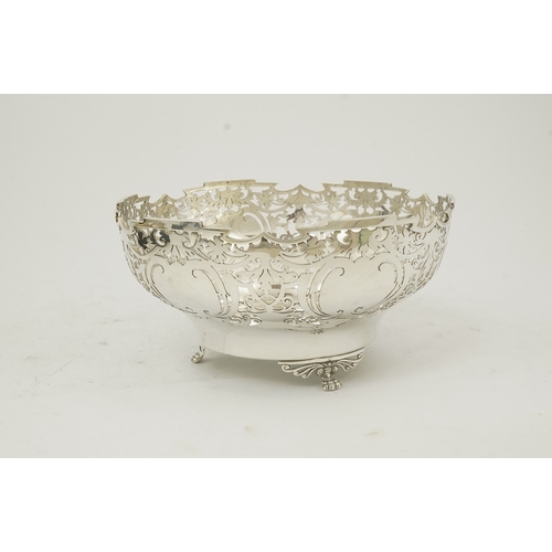 85 - An Elizabeth II pieced silver fruit bowl, by Walker & Hall, with scroll piercing, on three scroll an... 