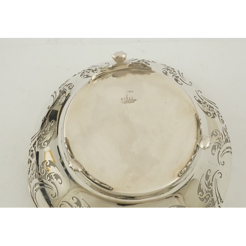 85 - An Elizabeth II pieced silver fruit bowl, by Walker & Hall, with scroll piercing, on three scroll an... 