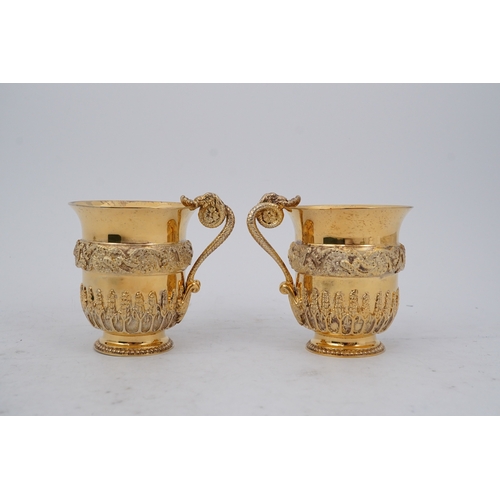 92 - An ornate pair of Elizabeth II silver gilt cups, by Richard O.A. Jarvis, decorated with a foliate an... 