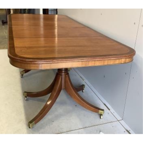 1021 - A reproduction mahogany twin pillar extending dining table, extended 300cm, two spare leaves, depth ... 