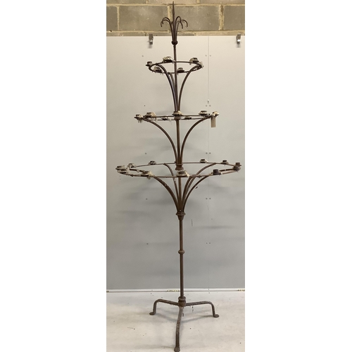 1063 - A pair of French wrought iron three tier candlestands, on tripod bases, diameter 95cm, height 254cm.... 