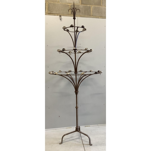 1063 - A pair of French wrought iron three tier candlestands, on tripod bases, diameter 95cm, height 254cm.... 