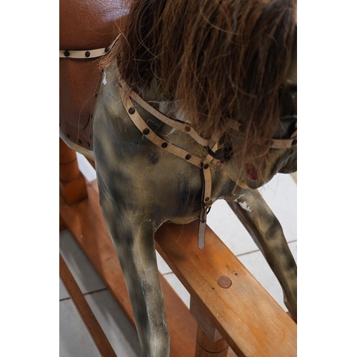 1122 - An early 20th century dapple grey rocking horse, on later trestle base, length 132cm. Condition - fa... 