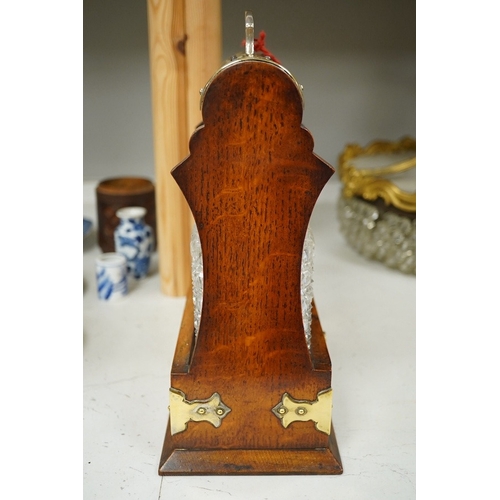 1374 - A brass mounted two bottled oak tantalus, 24cm wide, 33cm high. Condition - fair to good