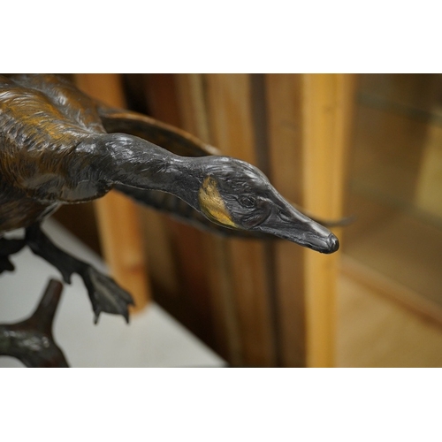 1398 - A modern large cast bronze sculpture of two flying geese, on an oval plinth, 90cm wide. Condition - ... 