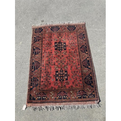 100 - A Belouch red ground rug, 140 x 108cm