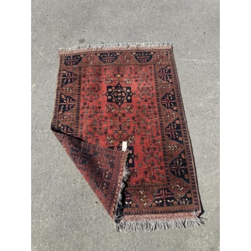 100 - A Belouch red ground rug, 140 x 108cm